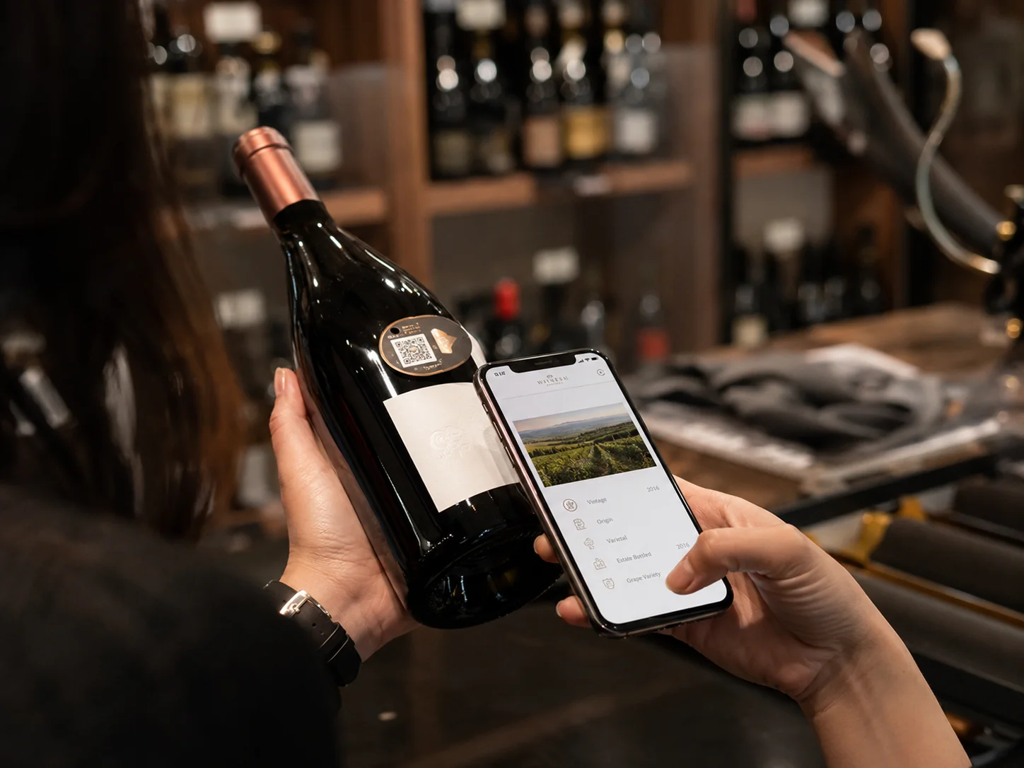 Scansione di una bottiglia di vino con tag digitale in ambiente di cantina